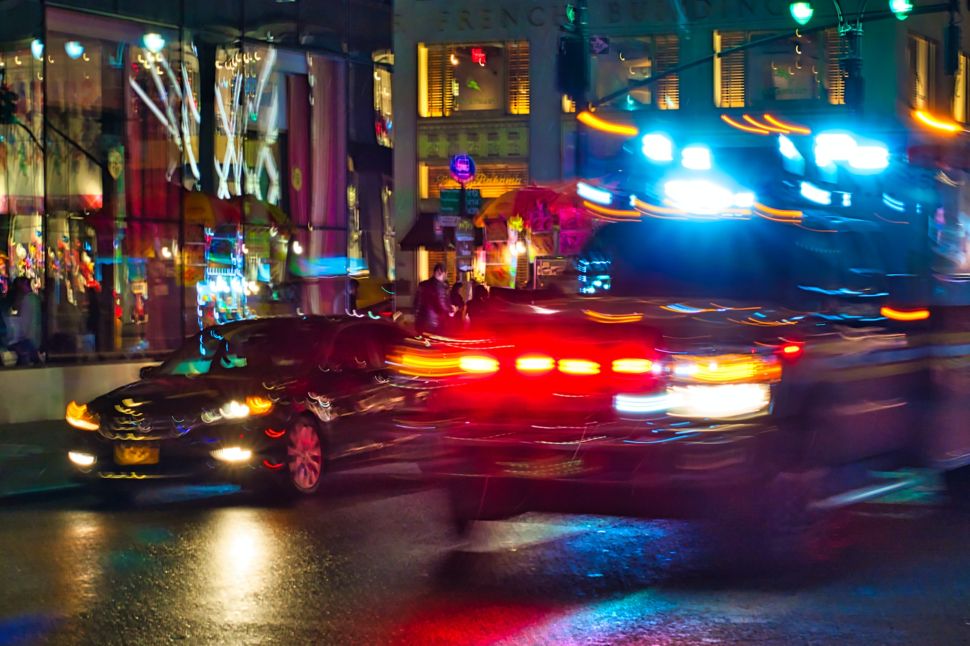 An emergency vehicle races down a busy city street